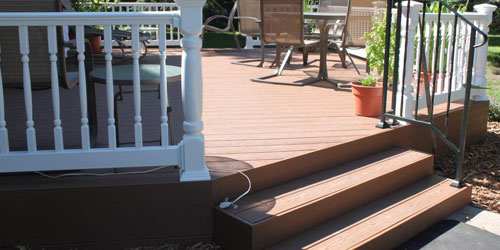 Maitenance free deck with wood colored decking and white railings