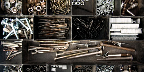 Aerial photo of a tool box with displaying compartments of nails, screws, bolts, washers, and other hardware
