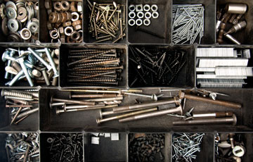 Aerial photo of an open storage chest with compartments filled with nails, bolts, screws, washers and other hardware