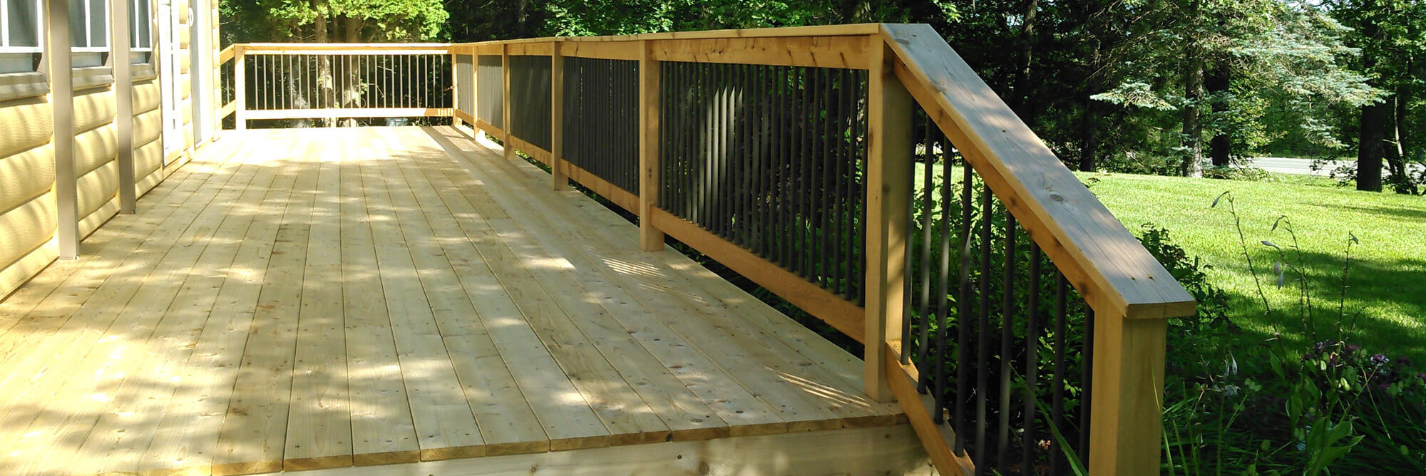 Newly constructed cedar wood deck with wrought iron railings